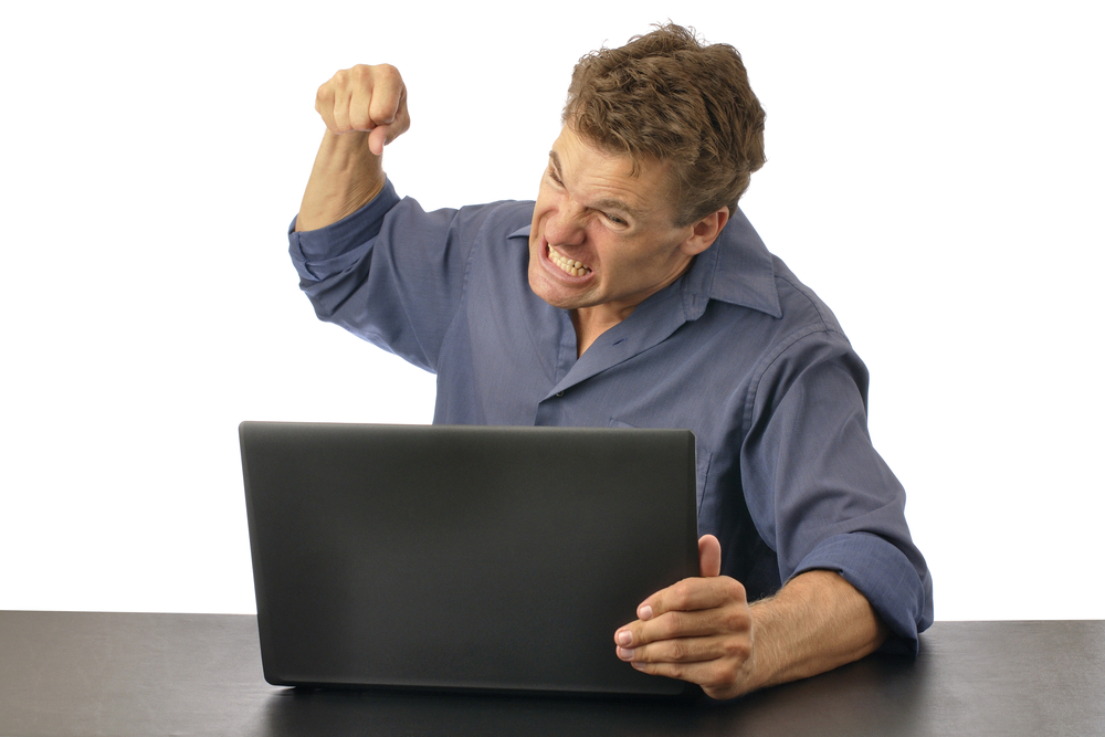 Angry man punching computer isolated on white background